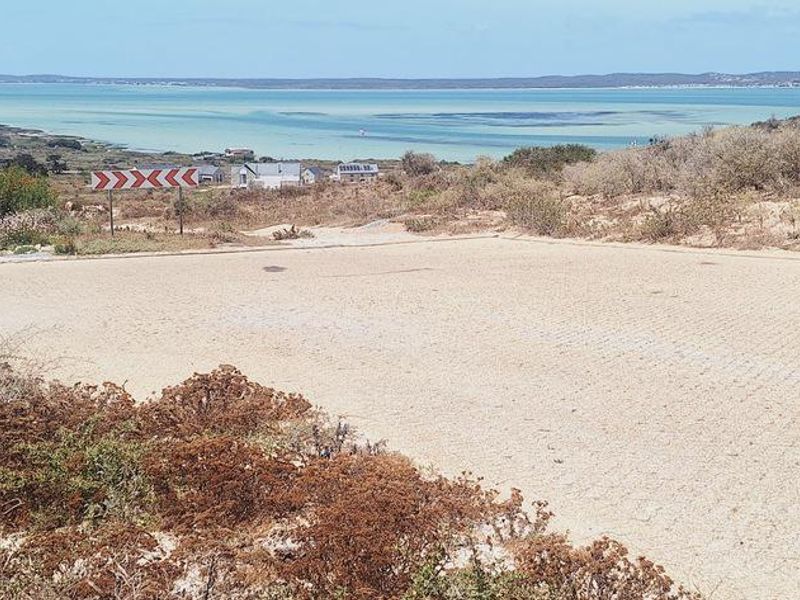 A scenic view of the coastal landscape and lagoon from the vacant residential property, featuring a paved driveway area.