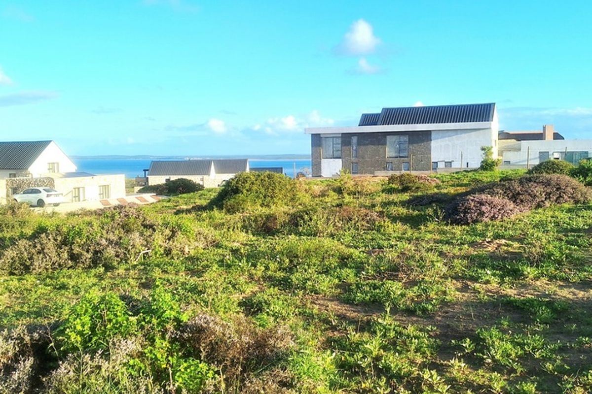 A scenic view of the surrounding residential estate and coastal landscape, showcasing the natural terrain and nearby modern architectural developments.