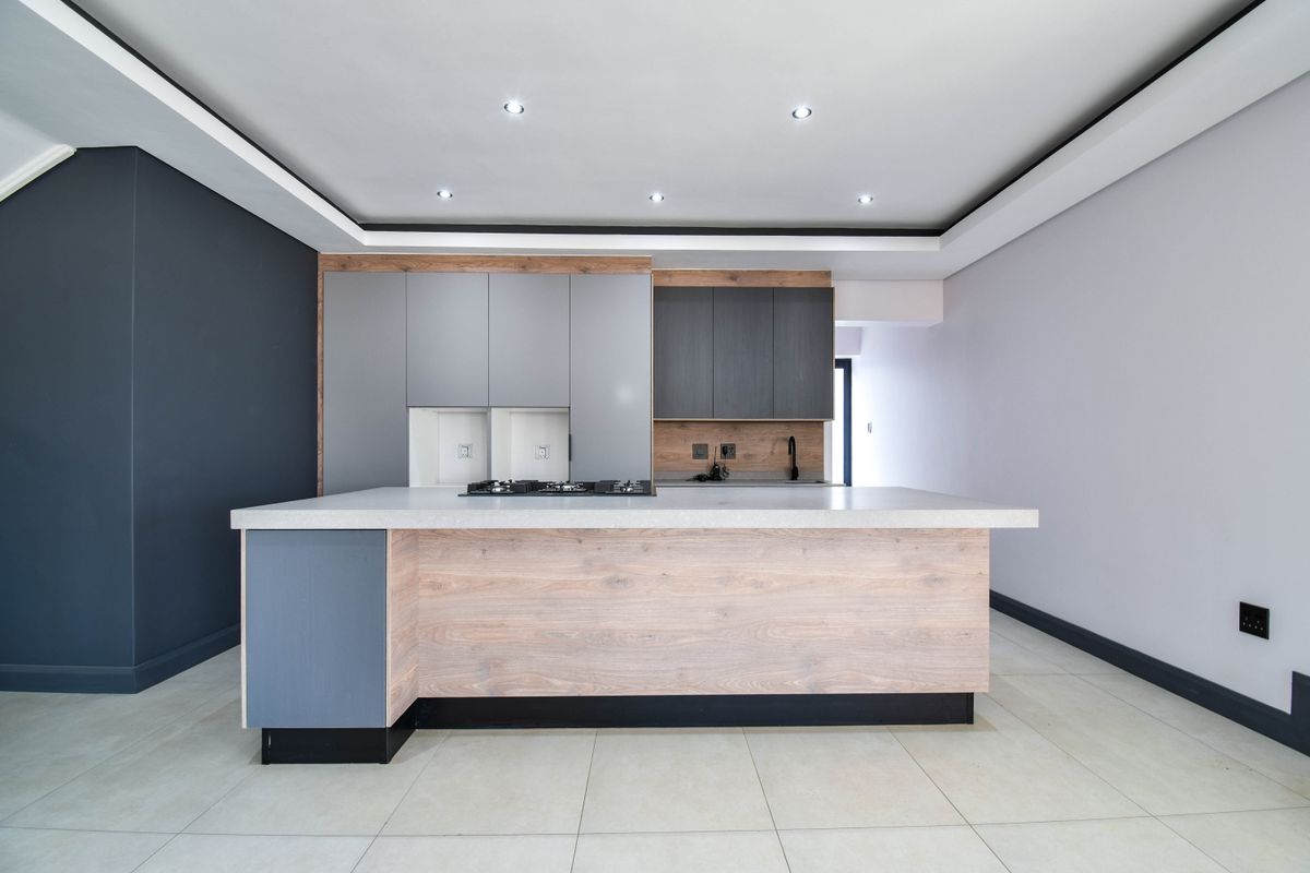 Modern kitchen featuring a central island with a built-in gas hob, sleek cabinetry, and recessed ceiling lighting.