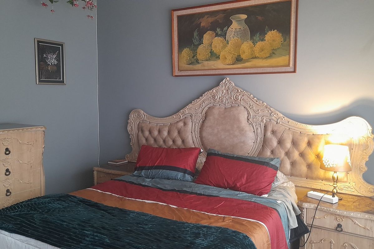 A bedroom featuring a decorative tufted headboard and matching bedside cabinetry, providing a classic aesthetic.