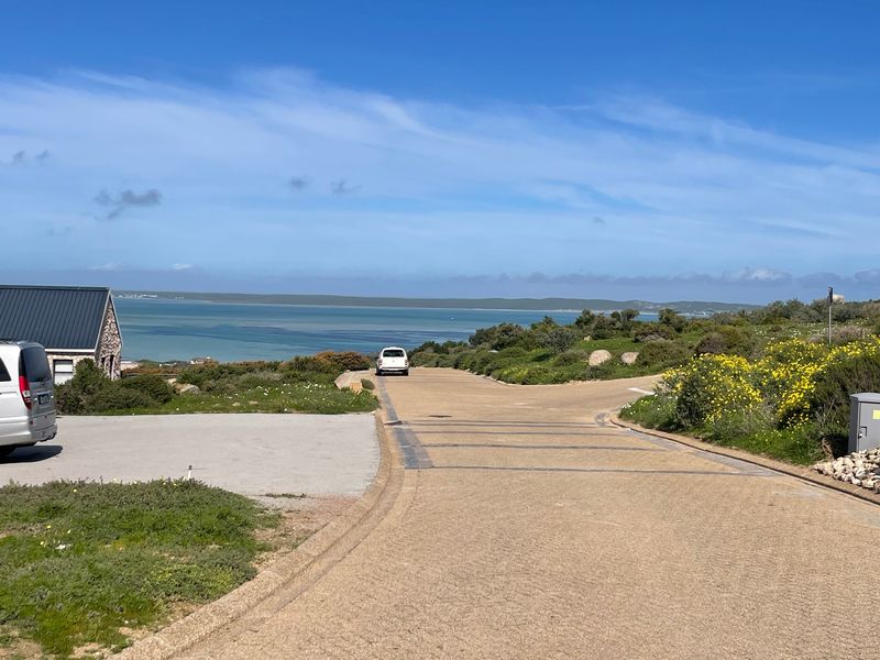 A scenic view of the coastal landscape and ocean from a paved residential street within the estate.