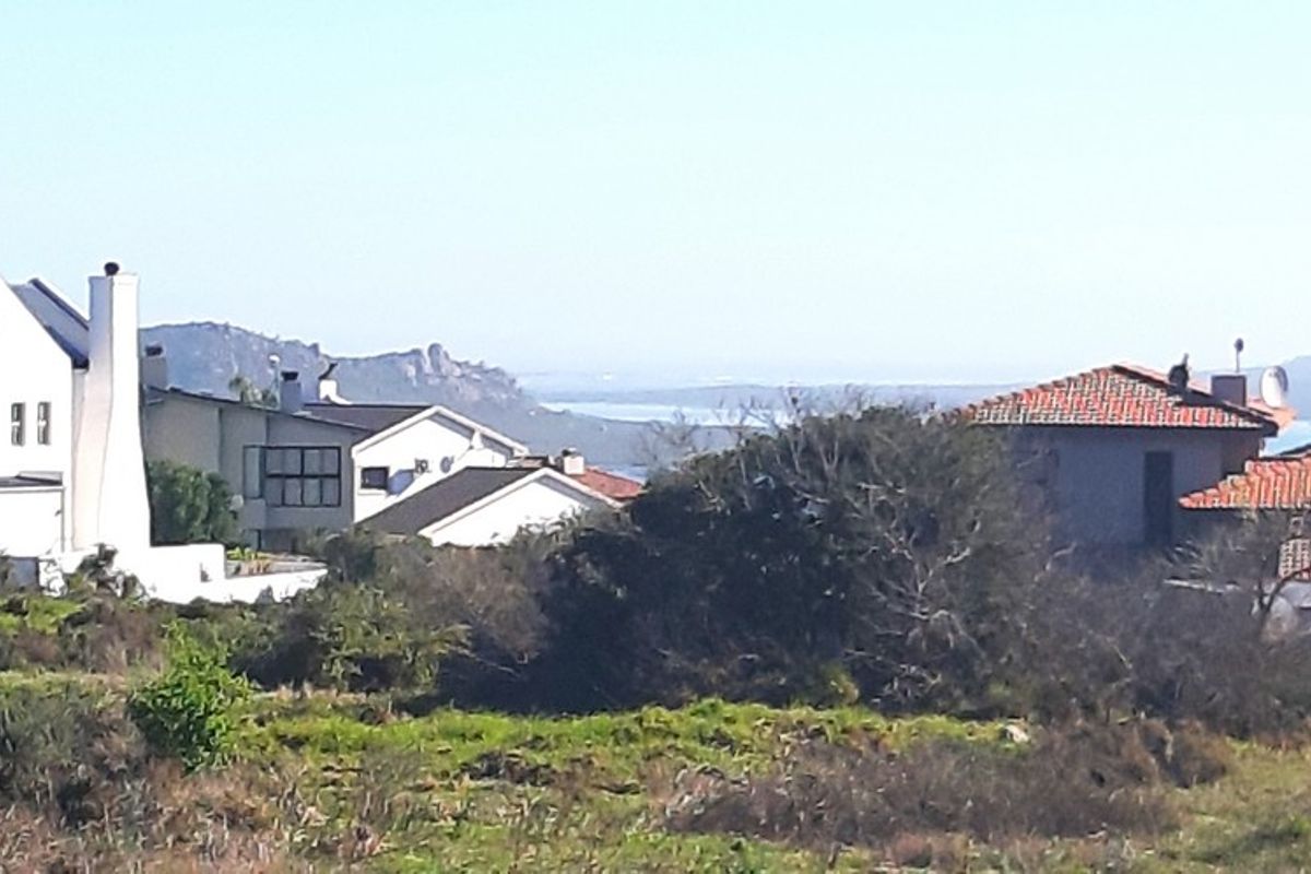 A view of the surrounding residential neighborhood and distant landscape from the vacant land plot.