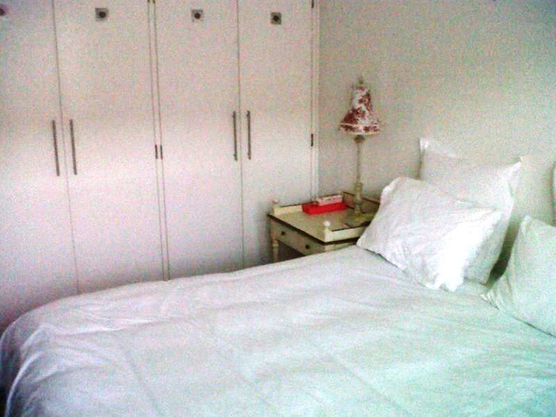 A bedroom featuring white built-in cupboards providing ample storage space.