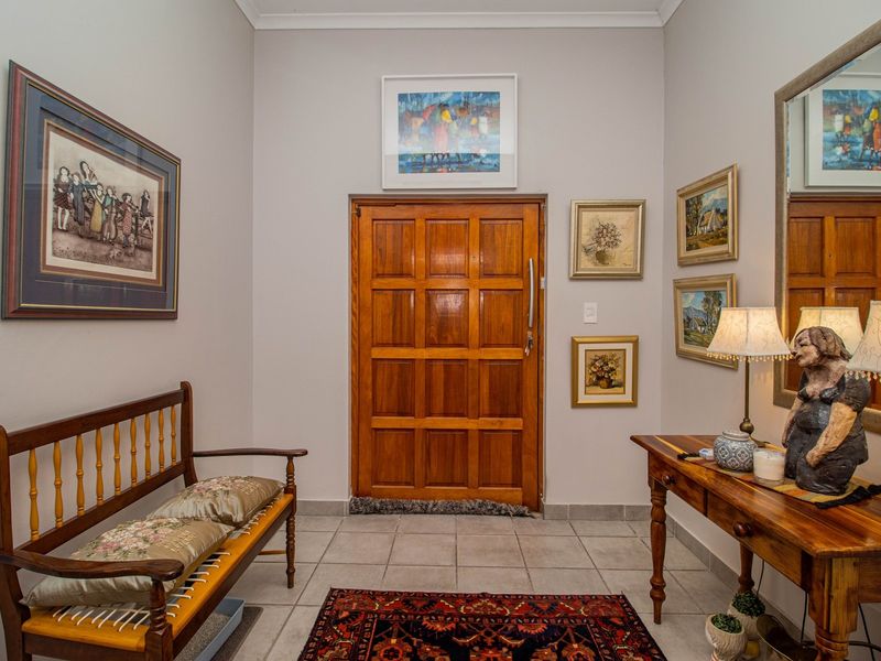 A welcoming entrance foyer featuring a solid timber panelled front door and neutral ceramic floor tiling.