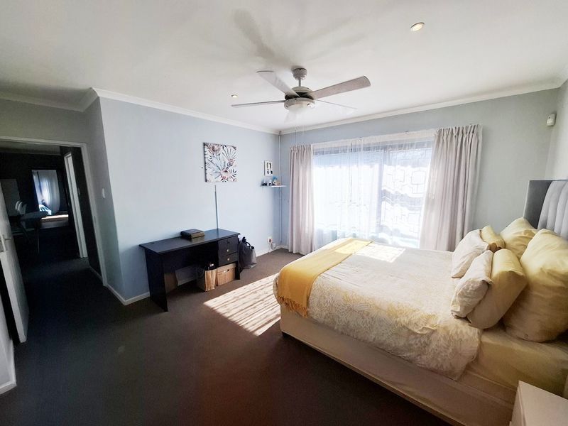 A well-lit bedroom featuring a ceiling fan, recessed lighting, and neutral wall finishes, providing a comfortable and functional living space.