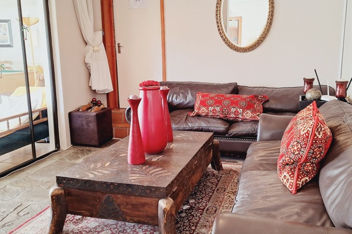 A comfortable living room featuring stone flooring and large sliding glass doors that provide access to an adjacent patio area.