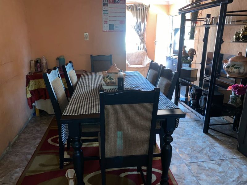 A dining room area featuring tiled flooring and textured walls, providing a functional space for family meals.