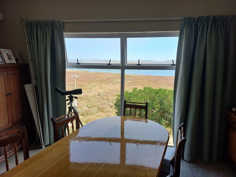 Dining area featuring a large window with expansive views of the surrounding landscape and water.