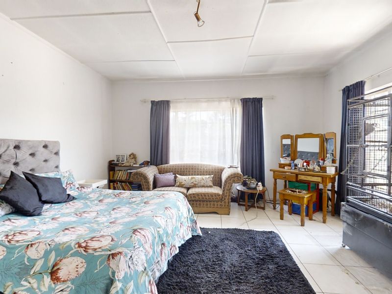 Spacious bedroom featuring tiled flooring and a tiled ceiling, offering a functional layout with ample natural light.