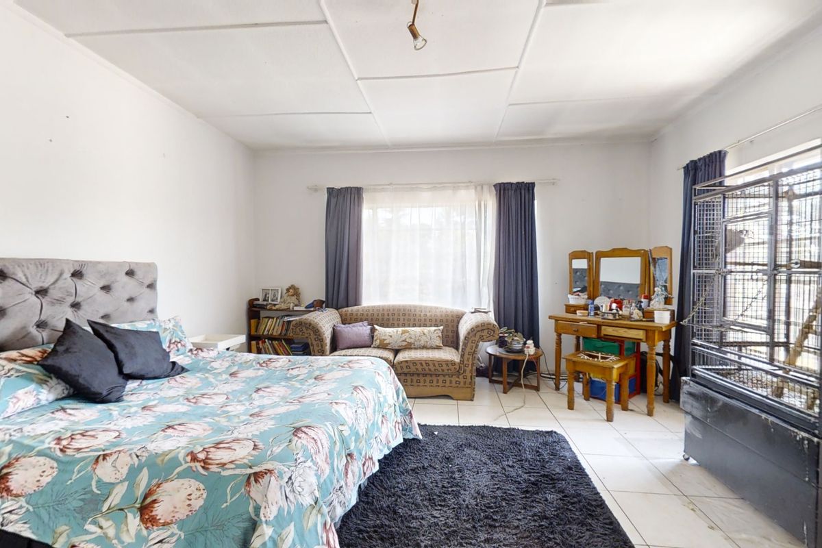 Spacious bedroom featuring tiled flooring and a tiled ceiling, offering a functional layout with ample natural light.