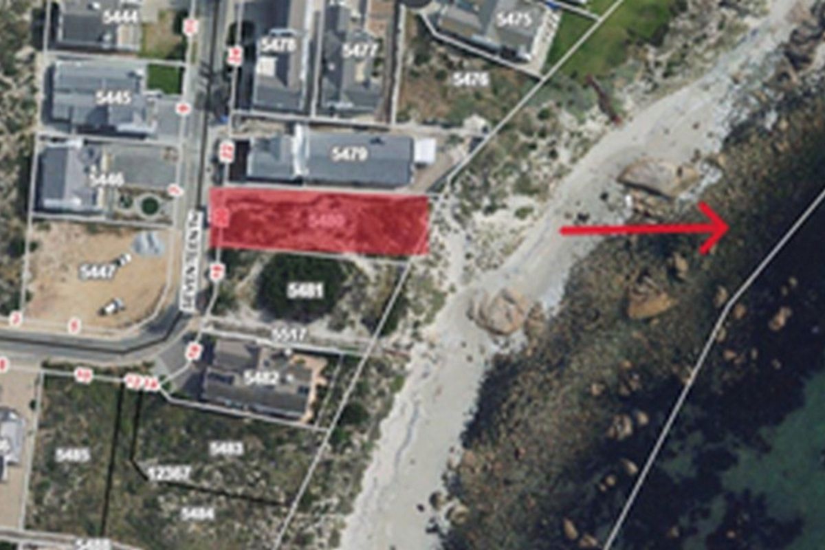 An aerial view of a vacant residential land parcel situated in a coastal location with direct proximity to the beach.