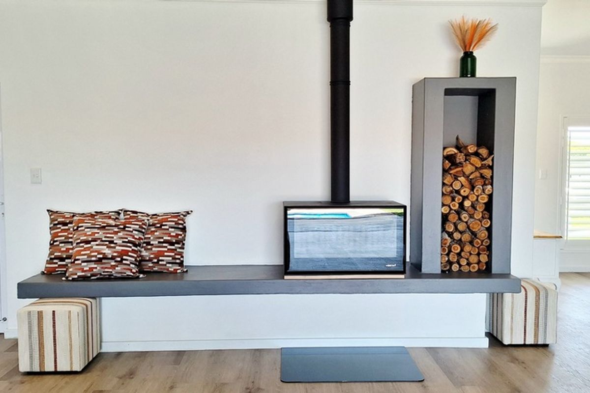 Modern living room featuring a sleek built-in fireplace with a floating hearth and integrated wood storage niche, complemented by light wood-look flooring.