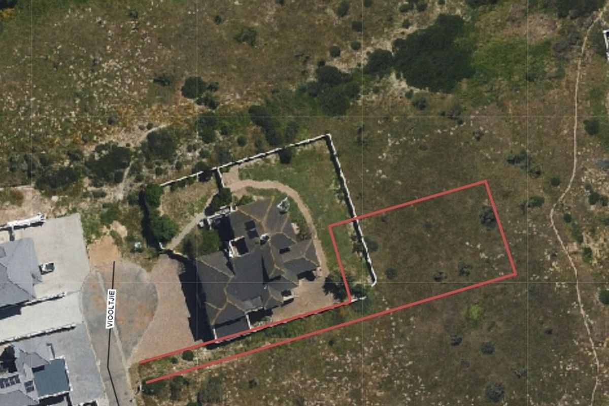 Aerial view of a residential vacant land plot with boundary lines indicated, situated in a coastal or semi-rural development.