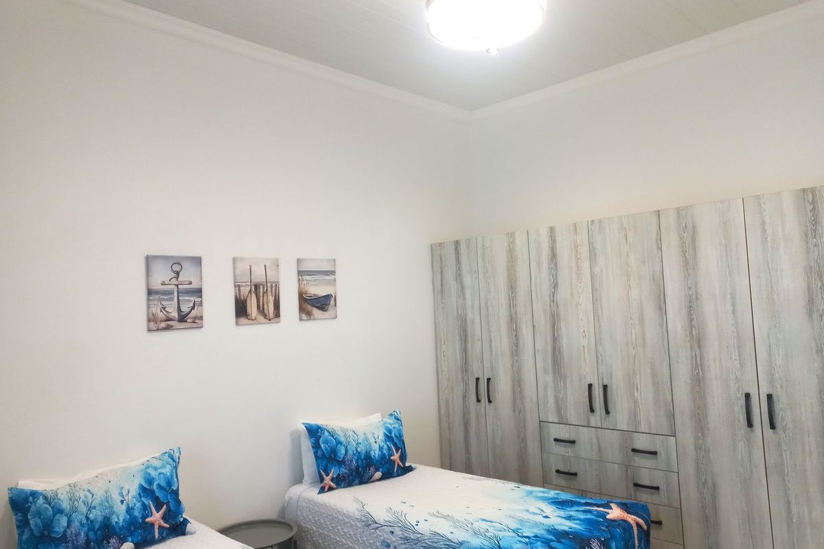 A bedroom featuring built-in wooden cabinetry with integrated drawers and a flush-mount ceiling light fixture.