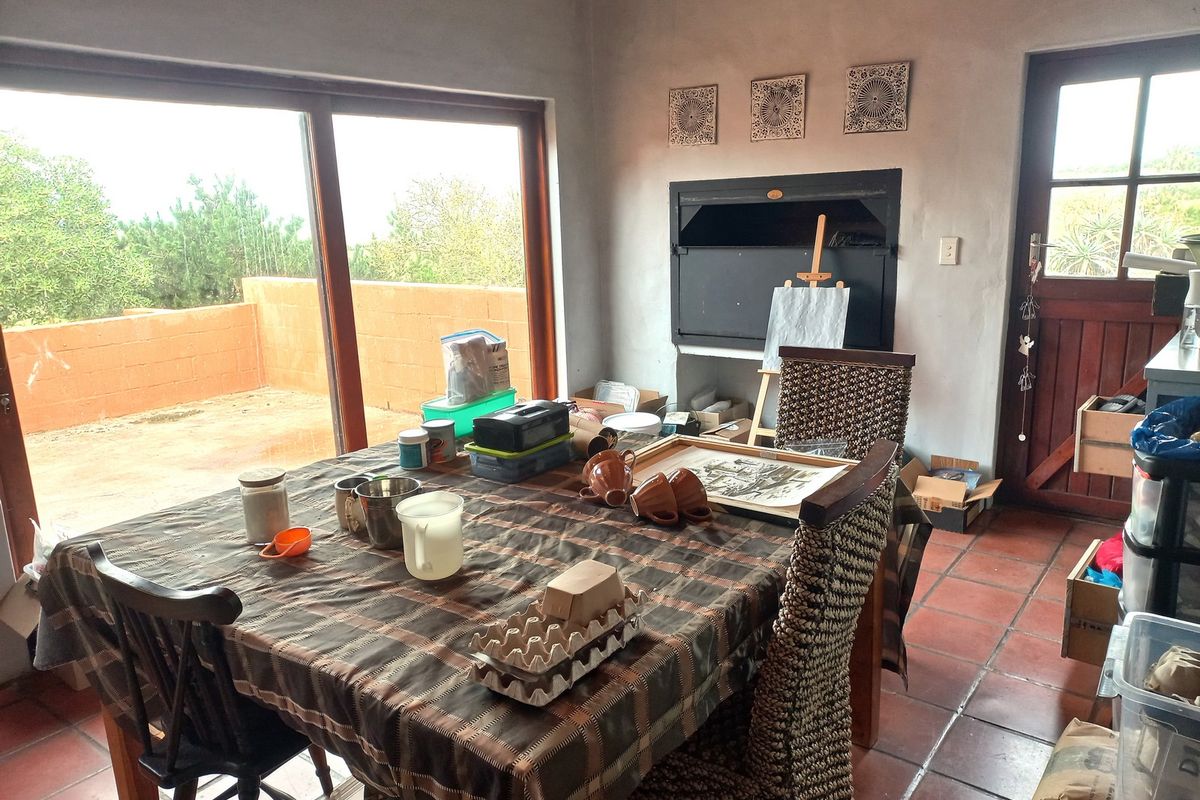Living area featuring terracotta floor tiles, a built-in fireplace, and large sliding glass doors providing access to an outdoor patio area.