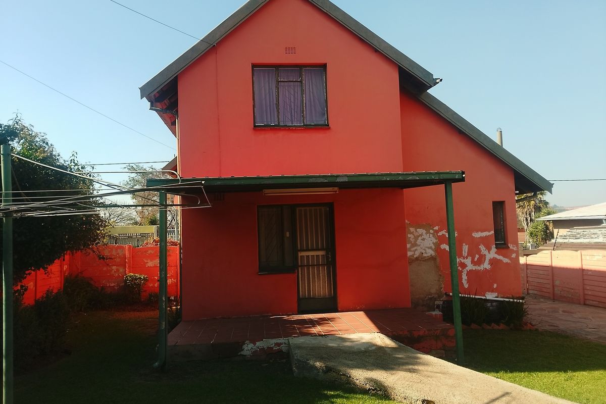 Exterior view of a two-story house featuring a covered patio, tiled entrance, and a small garden area.