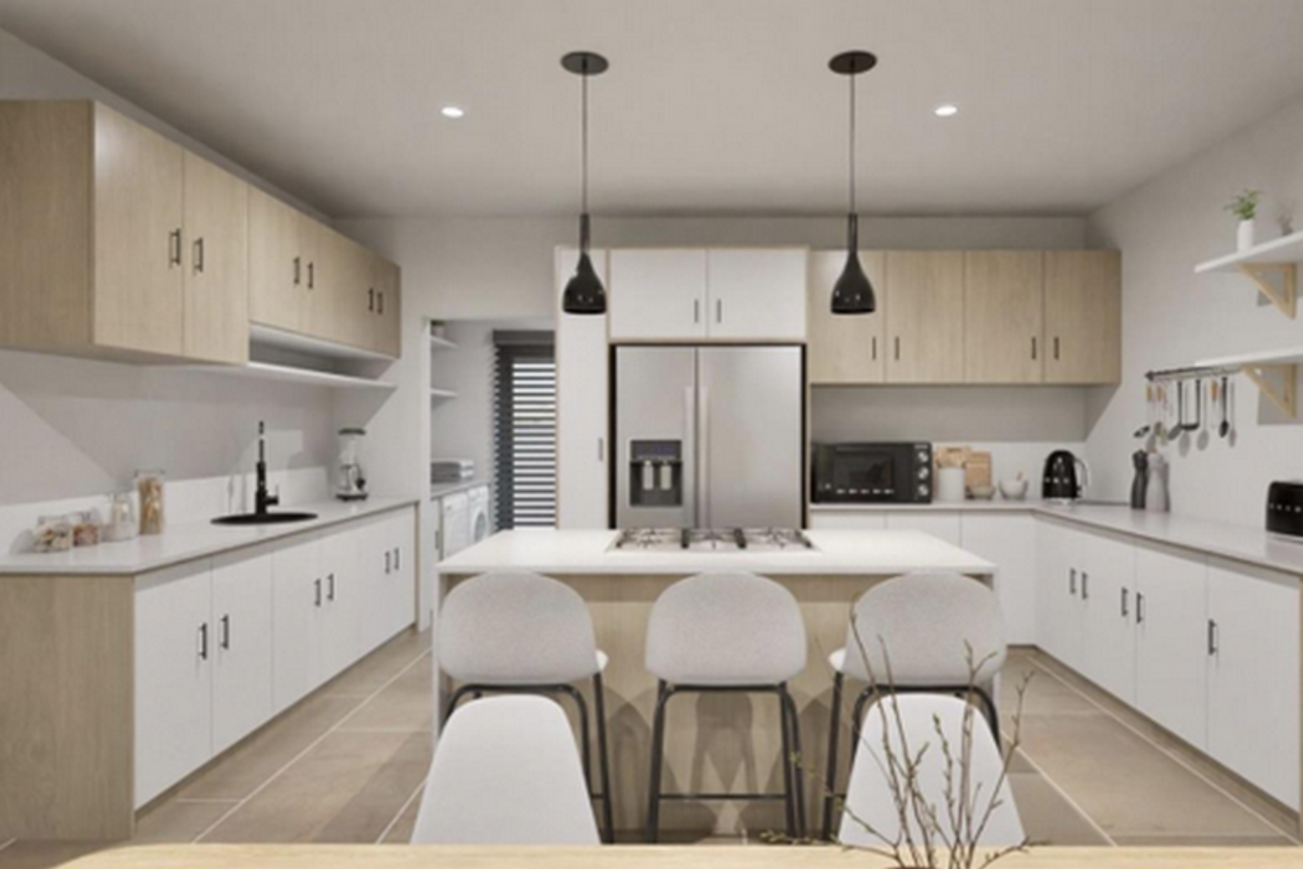Modern kitchen featuring a central island with integrated gas cooktop, light wood cabinetry, white countertops, and sleek pendant lighting.