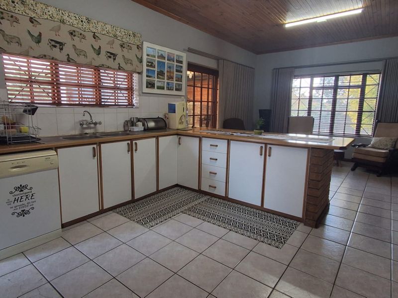 Open plan kitchen featuring laminate cabinetry, tiled flooring, and a brick-based breakfast bar, seamlessly flowing into the adjacent living area.