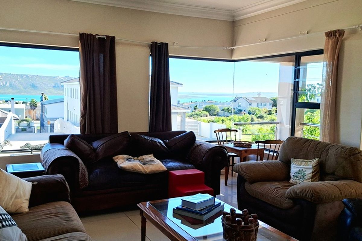 Spacious living room featuring large corner windows that provide expansive views and abundant natural light, complemented by neutral tiled flooring.