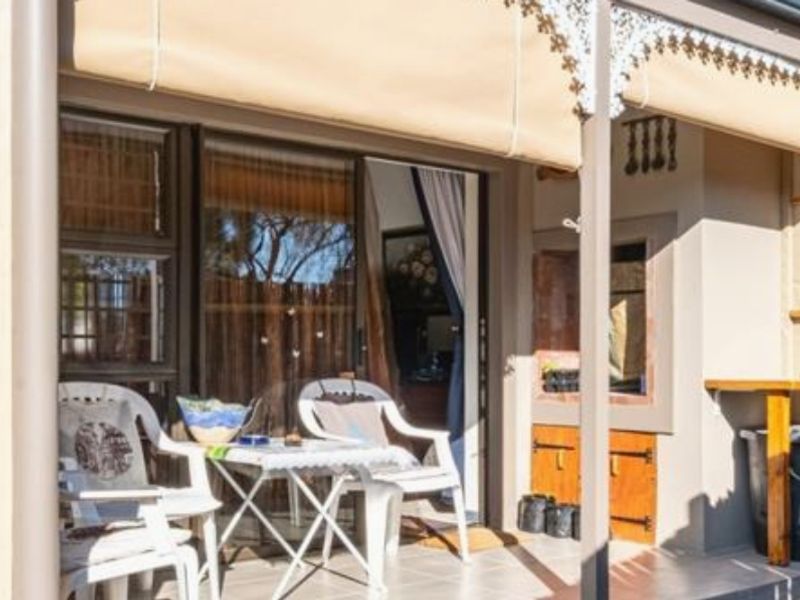 A covered patio area featuring tiled flooring, built-in cabinetry, and sliding glass door access to the interior living space.