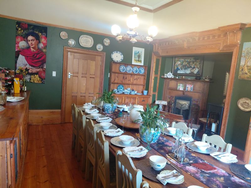 Spacious dining room featuring original timber flooring, a classic fireplace with a wooden mantel, and traditional architectural detailing.