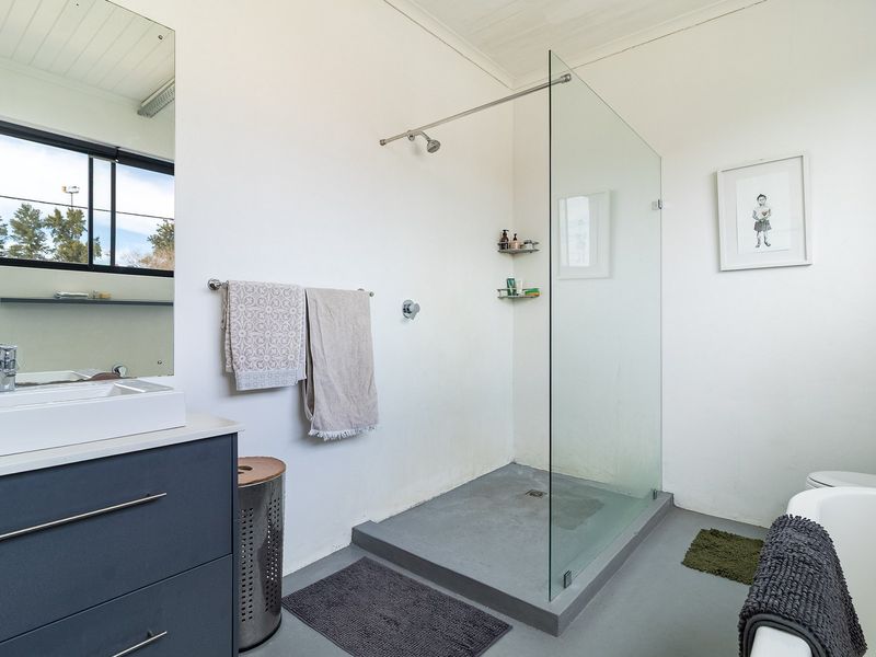 Modern bathroom featuring a walk-in shower with glass screen, vanity unit with basin, and a freestanding bathtub.