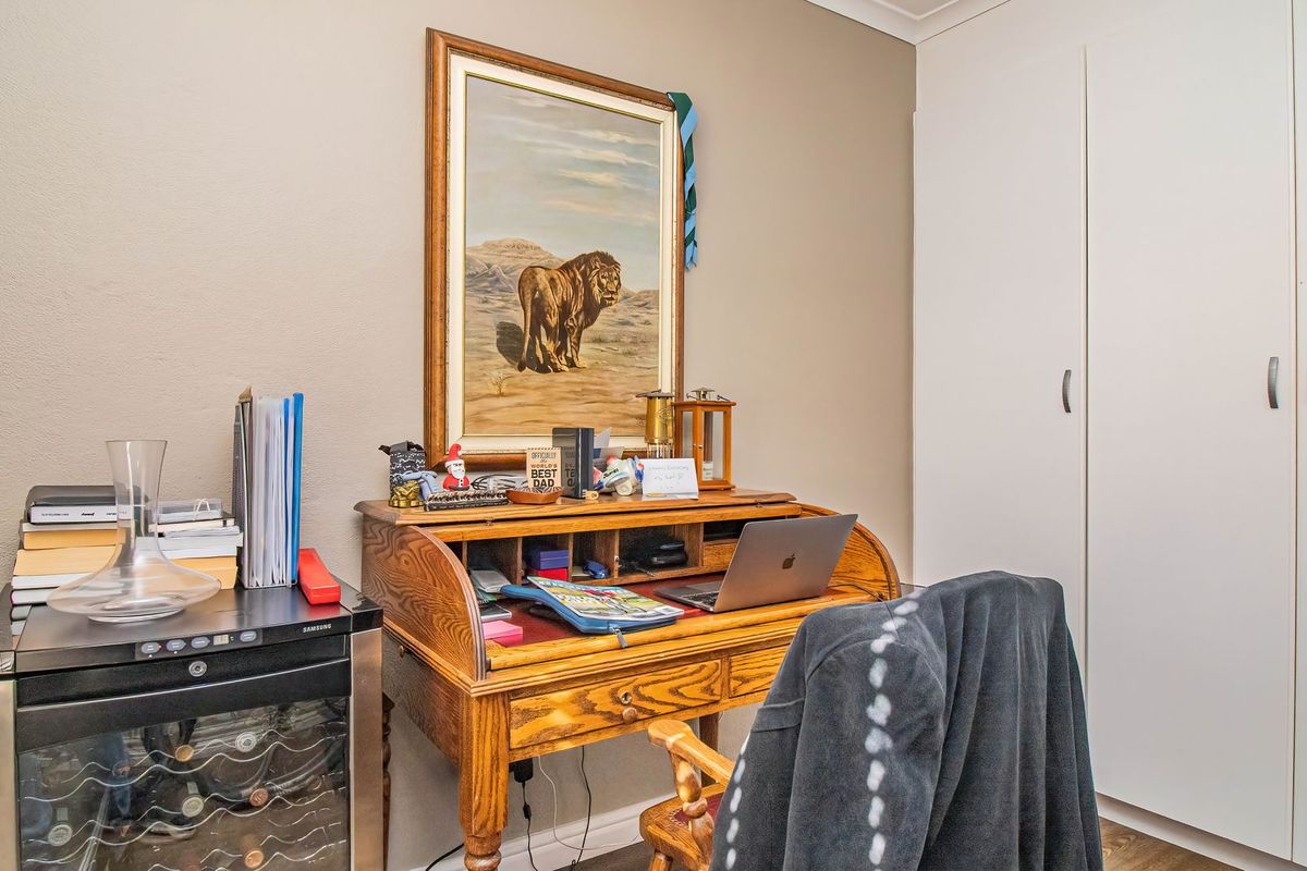 A bedroom featuring neutral wall tones and functional built-in storage cupboards, providing a practical space for rest or home office use.