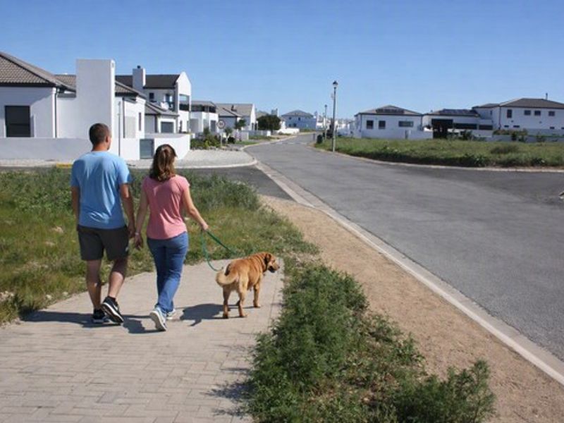 A view of the residential street and paved sidewalk within the estate, showcasing the surrounding neighborhood infrastructure.