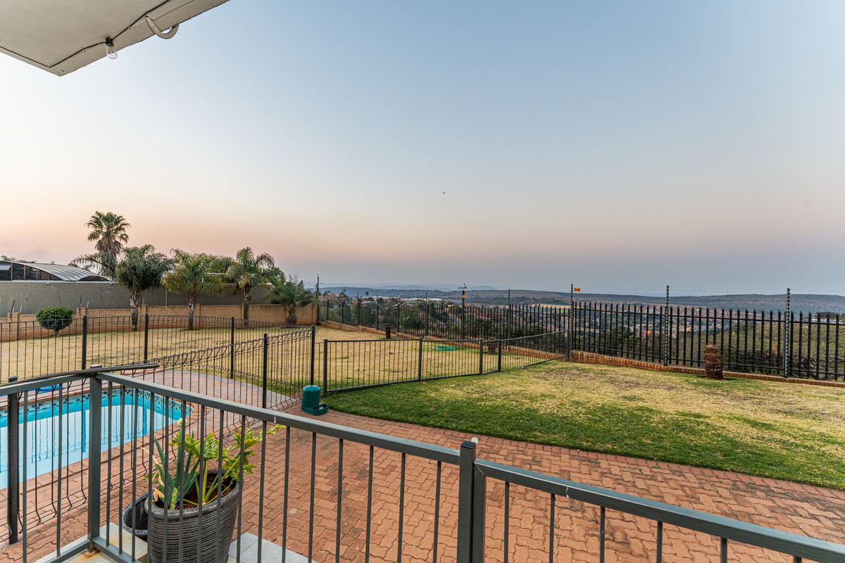 Rear garden featuring a swimming pool, paved patio area, and expansive views, secured by metal and electric fencing.