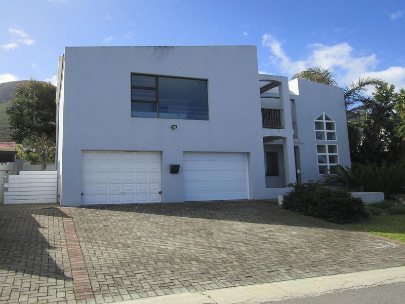 Front elevation of a modern double-story house featuring a double garage, paved driveway, and an upper-level balcony.