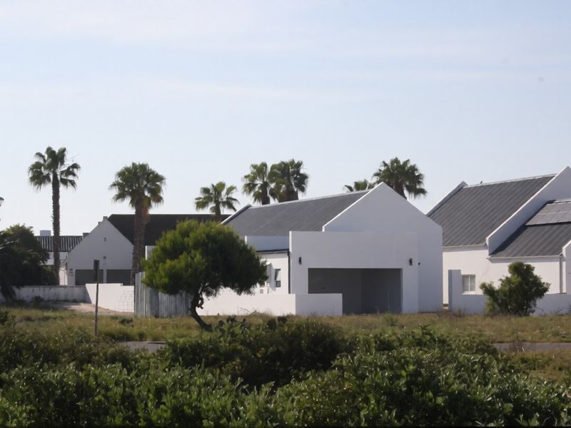 A view of modern residential houses featuring pitched roofs, integrated garages, and solar panels set within a landscaped estate environment.