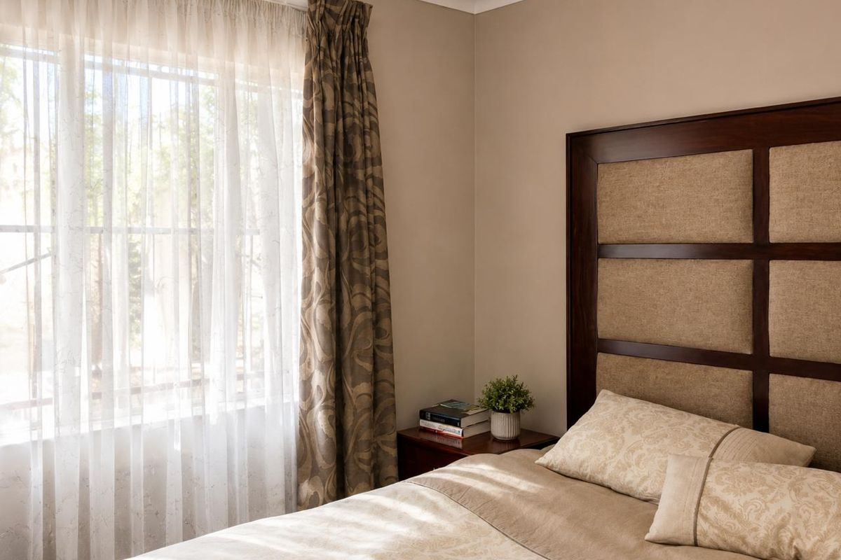 A well-maintained bedroom featuring neutral wall tones, coving, and a large window allowing natural light to enter the space.