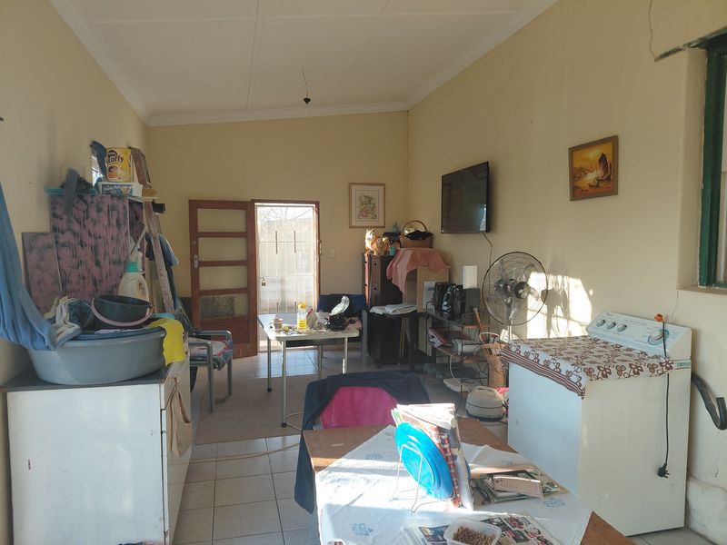 A functional laundry area featuring tiled flooring and direct access to the exterior, providing a practical space for utility and household tasks.