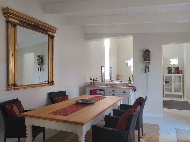 A bright dining room featuring exposed beam ceilings and a built-in serving counter, creating an open and inviting space for meals.
