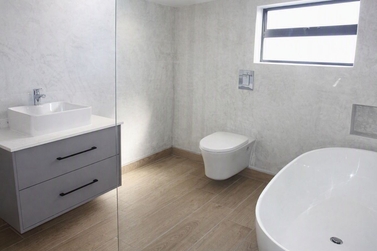 Modern bathroom featuring a wall-mounted vanity, vessel sink, wall-hung toilet, and a sleek freestanding bathtub with contemporary finishes.