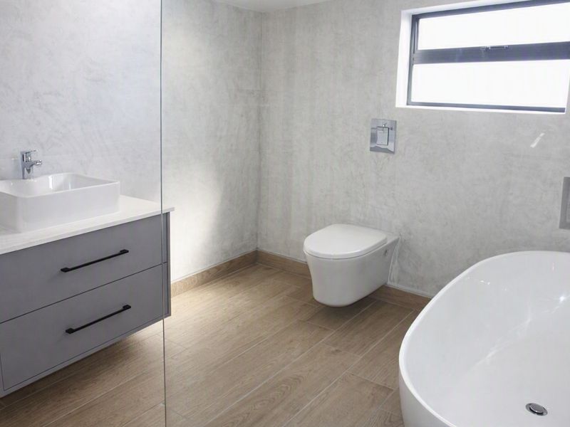 Modern bathroom featuring a wall-mounted vanity, vessel sink, wall-hung toilet, and a sleek freestanding bathtub with contemporary finishes.