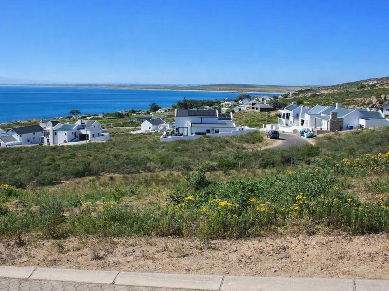 A scenic elevated view overlooking a coastal residential estate with ocean vistas and surrounding natural landscape.