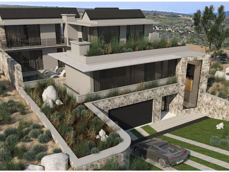 An aerial perspective of a modern architectural residence featuring stone cladding, integrated roof gardens, and a swimming pool set within a natural landscape.