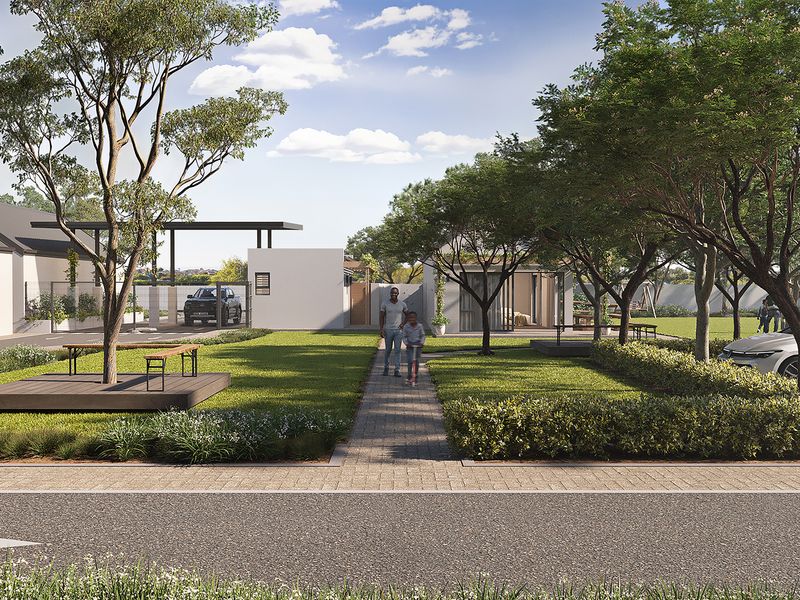 A modern townhouse complex exterior featuring a landscaped garden, paved walkways, and dedicated parking areas within a well-maintained residential estate.