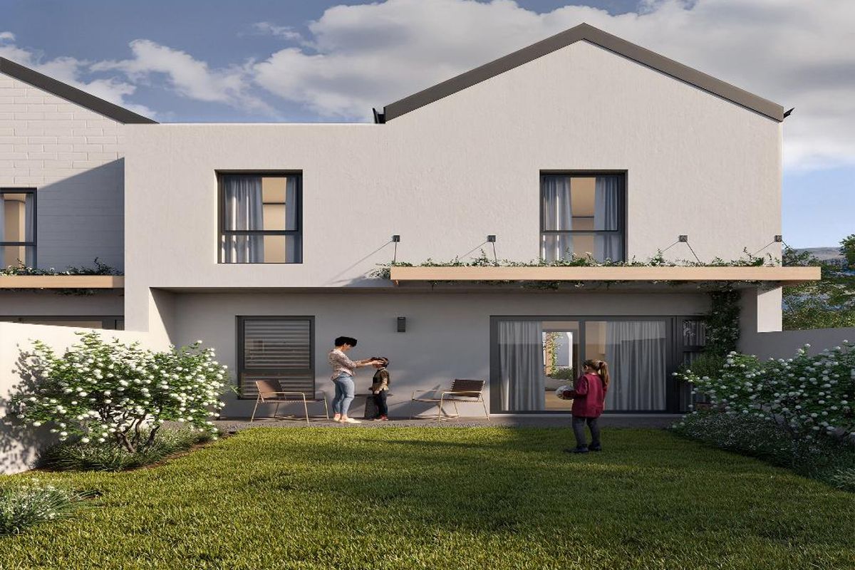 Rear view of a modern townhouse featuring a private garden, a ground-floor patio with sliding glass doors, and an upper-level balcony.