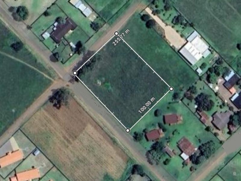 Aerial view of a vacant residential plot with clearly marked boundaries, situated in a developed neighborhood.