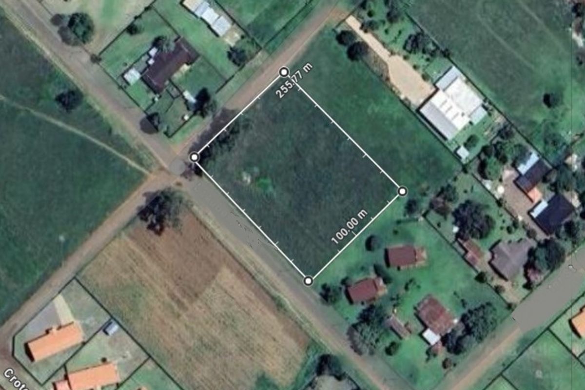 Aerial view of a vacant residential plot with clearly marked boundaries, situated in a developed neighborhood.
