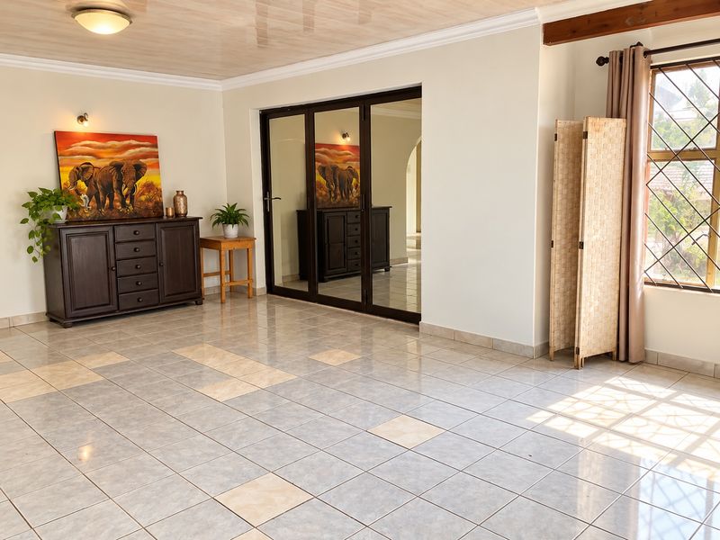 Spacious living area featuring neutral tiled flooring, large sliding glass doors, and natural light, providing a versatile space for comfortable family living.