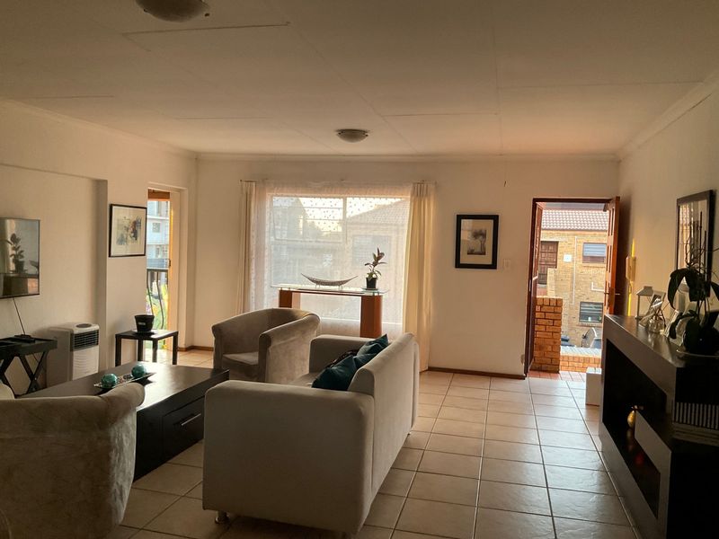 Spacious living room featuring tiled flooring, a built-in fireplace, and direct access to an outdoor area through a sliding door.