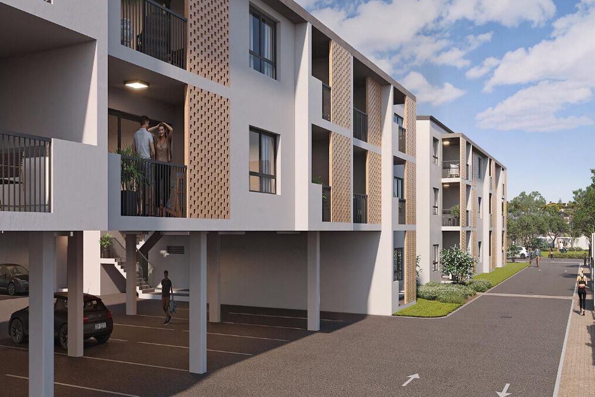 Modern apartment complex featuring covered ground-level parking, private balconies with decorative brick screening, and well-maintained exterior finishes.