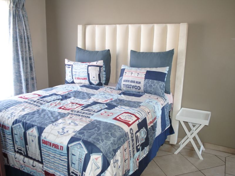 A bedroom featuring tiled flooring and neutral wall tones, providing a functional space for rest.