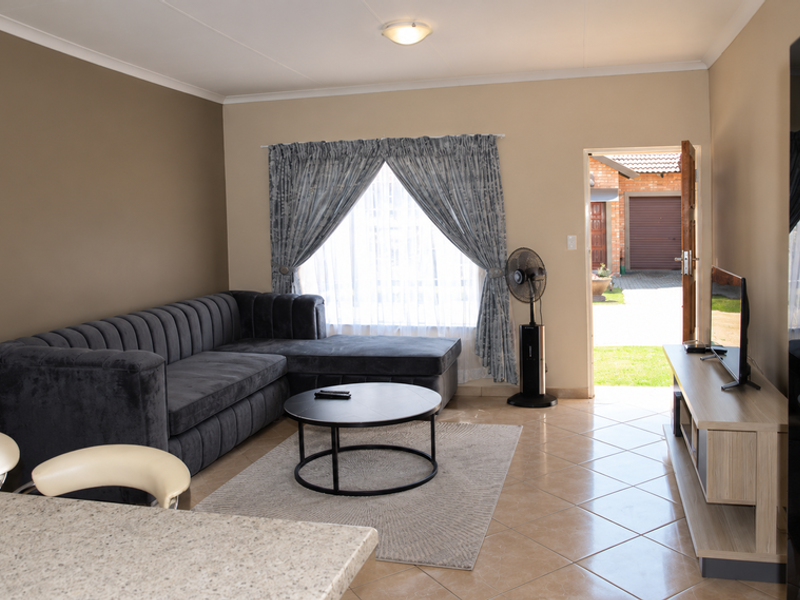 Open plan living area featuring tiled flooring and direct access to the exterior, creating a bright and functional space.