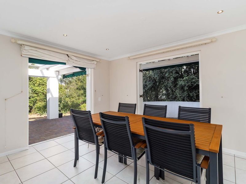 Bright dining area featuring ceramic floor tiles, recessed downlights, and direct access to an outdoor patio through sliding glass doors.