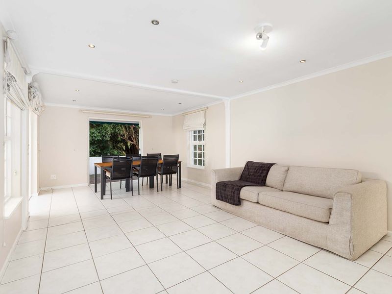 Spacious open-plan living and dining area featuring neutral tiled flooring, recessed lighting, and direct access to an outdoor patio through sliding glass doors.