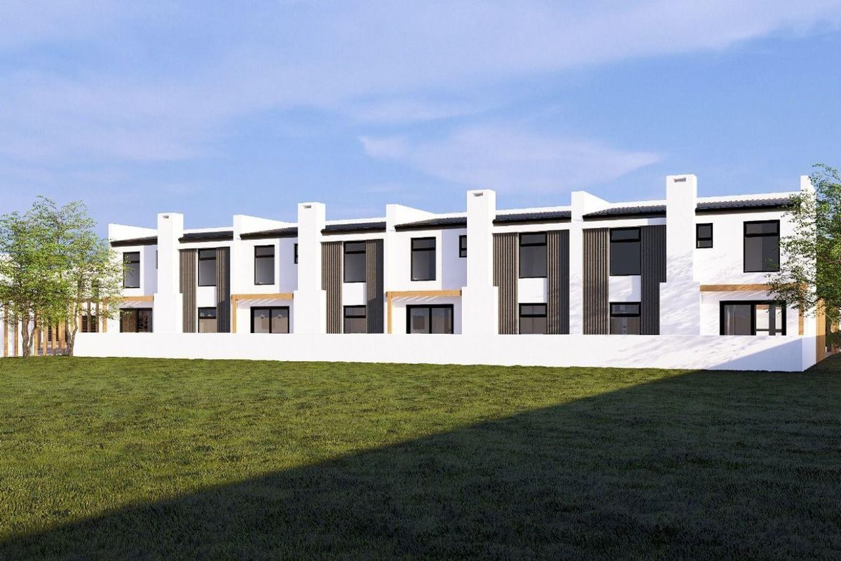 A modern townhouse complex exterior featuring clean white walls, dark vertical cladding, and chimney stacks, overlooking a spacious rear lawn area.